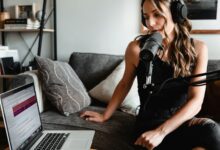 woman in black tank top sitting on couch using macbook