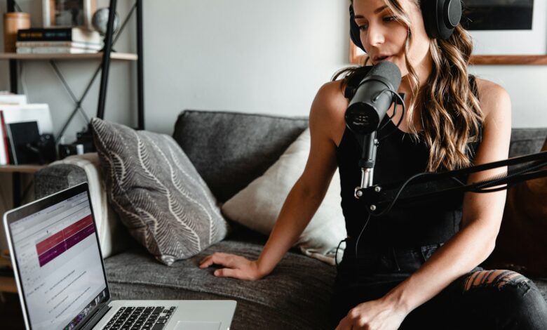 woman in black tank top sitting on couch using macbook